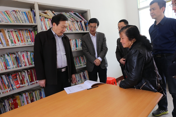1459305147180014582.jpg 新建的村级活动中心的图书室里,刘国繁等仔细查看村民的借阅记录_副本.jpg